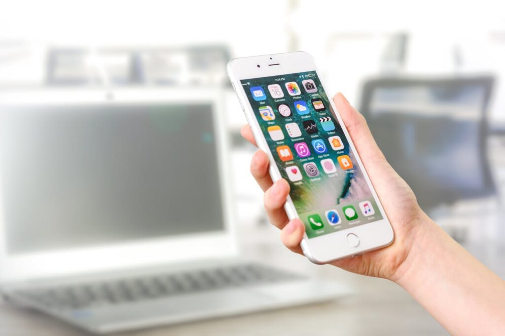 beginner web design tutorials. Learn mobile responsive design. A picture of a hand holding a phone.