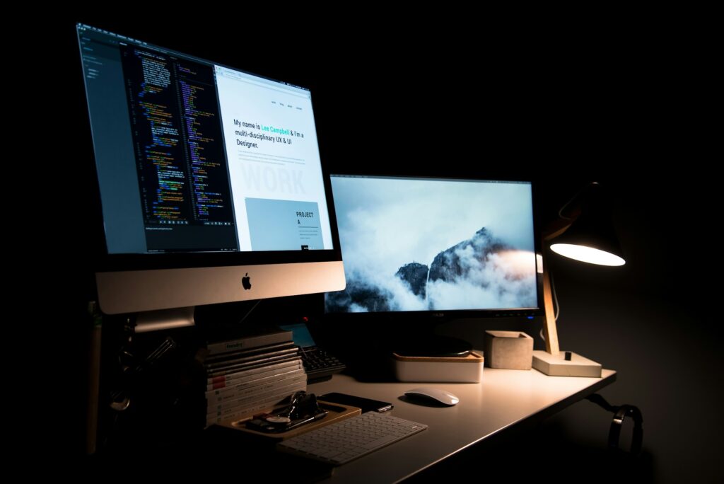why web design is important. First impressions matter. Shows a computer with code on it and the front end of a website as well.