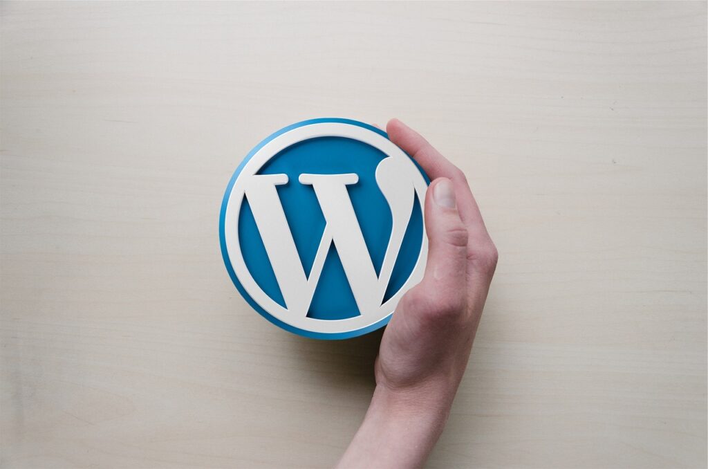 learning WordPress is fundamental if you are wanting to know how to start learning web designing. A picture of a hand wrapped aroun the WordPress logo.