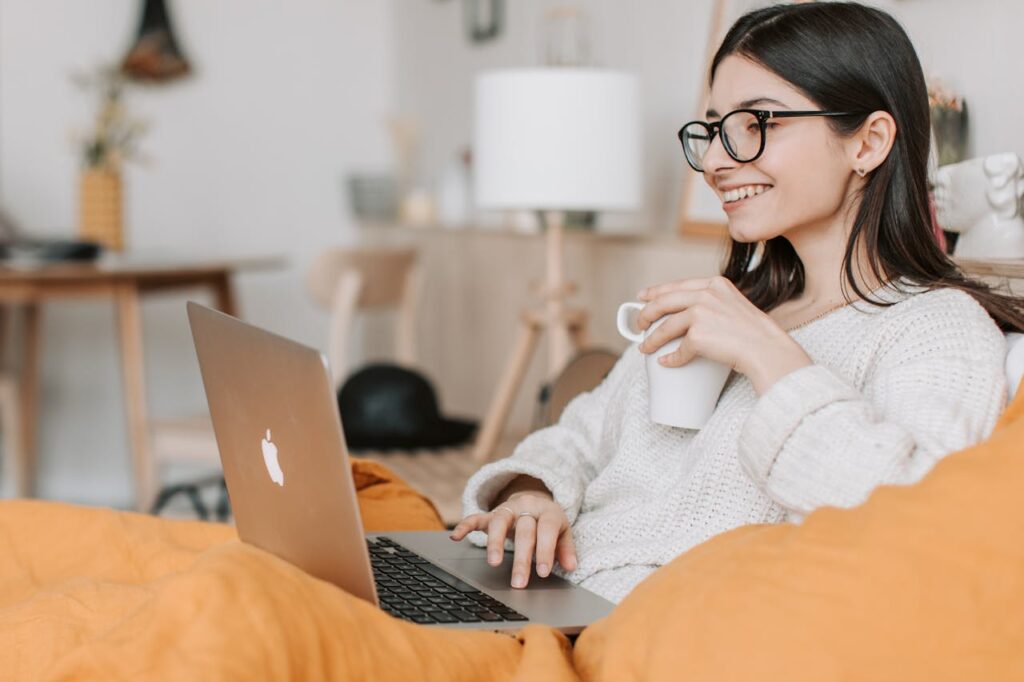 learn web designing and keep learning. A happy woman on a laptop that is learning correct web design methods